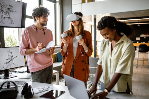Group of university students in the office using VR simulator headsets, having fun