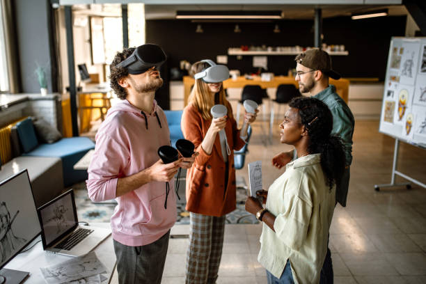Group of university students in the office using VR simulator headsets, having fun