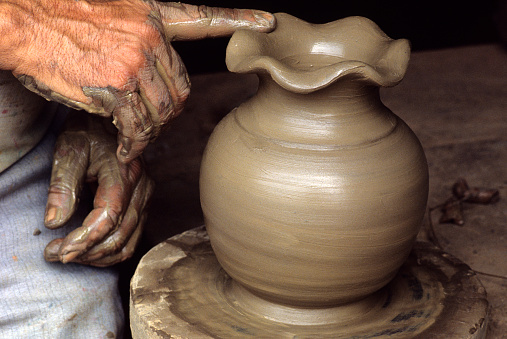 Hands making clay pot.