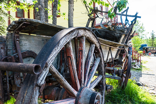 2 old wooden wagon wheels leaning against the wall in an old barn