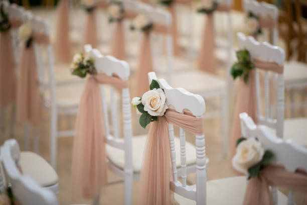 Wedding chairs with roses in wedding ceremony room