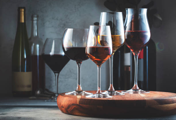 ワイングラスとボトルの品揃え。グレーのテーブル背景に赤、白、ロゼワイン。ワインバー、ショップ、テイスティングコンセプト - ワイン ストックフォトと画像