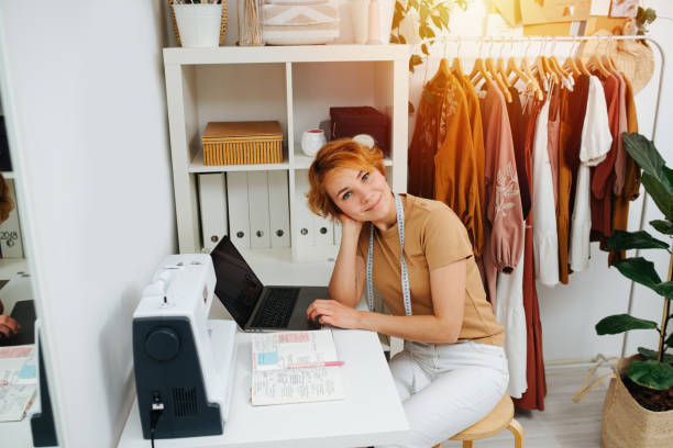 istock Friendly seamstress sitting behind her workdesk, working on laptop 1405516660