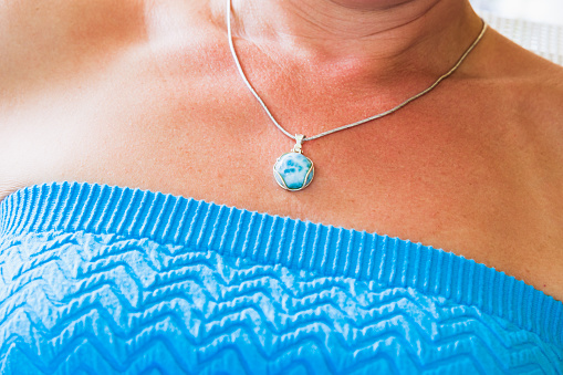 Silver necklace with round larimar stone, close up photo with selective focus