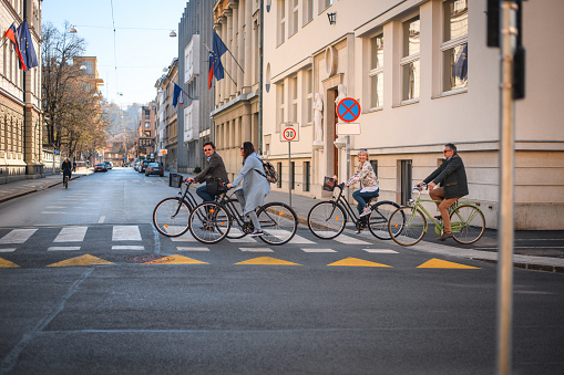 Salary workers are cycling in the city to work at rush hour.