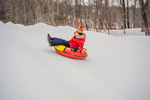 Pre-teen Boy On A Sled Playing In The Snow