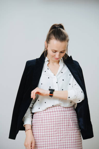 istock Busy thirty year old woman looking down at her watch, checking time 1405519103
