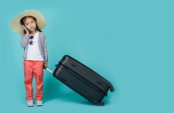 istock Asian little girl is using a smartphone to check flight to travel on weekends, empty space in studio shot isolated on colorful blue background 1405520121