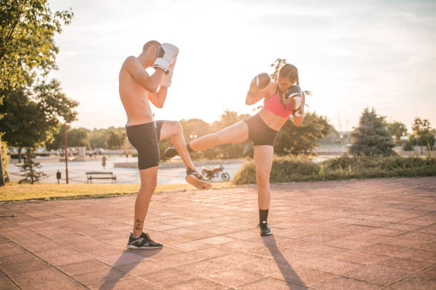 istock Young couple practice punches in the park 1405521498