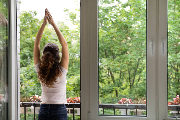 istock Rear view woman standing in terrace raise hands perform exercises 1405521759