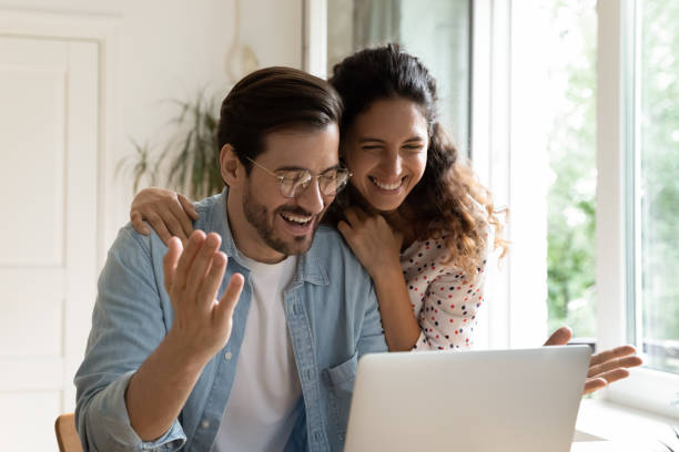 Happy couple reading great unbelievable amazing news on laptop Surprised happy cheerful 35s couple read great unbelievable amazing news on laptop, e-commerce cheery clients, online lottery winners celebrate victory, low price and special commercial offer concept unusual couple stock pictures, royalty-free photos & images