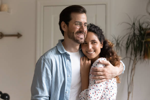 istock Loving husband hugging wife smiling looking away 1405522735