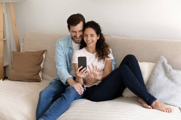 istock Couple relaxing indoor using smartphone enjoy internet entertainment make videocall 1405522753