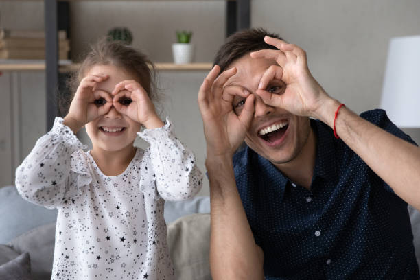 istock Cheerful cute kid making funny grimaces with dad. 1405522943