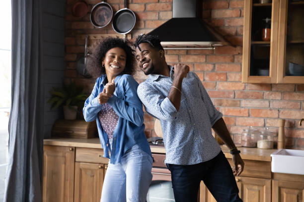istock Cheerful laughing young African American couple dancing in kitchen. 1405523010