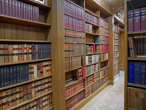 Library with wooden book shelves and bound sets of old legal texts