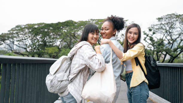 多様性あふれる多民族女子学生で、本を持ち、公園で自然の自然を眺める学生。カレッジや大学のコンセプトに備える。奨学金の機会を探している非公式の国家教育。 - multi national ストックフォトと画像