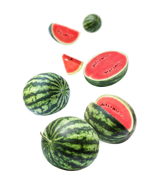 wassermelone mit geschnittener halbscheibe, die isoliert auf weißem hintergrund in der luft fliegt - watermelon fruit summer portion stock-fotos und bilder