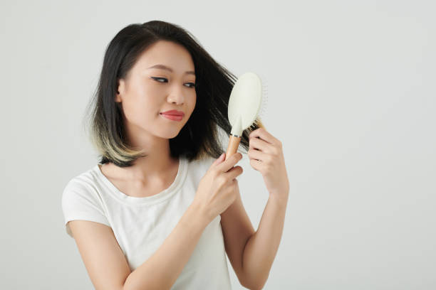 istock Smiling Woman Brushing Hair with Plastic Brush 1405532287