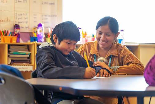 Indigenous Navajo Helpful teacher encouraging one of her students