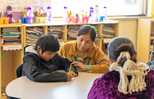 Indigenous Navajo Helpful teacher going around her class checking the students work
