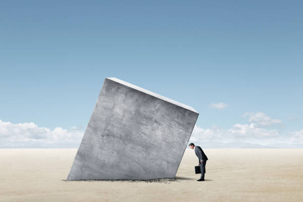 istock Man Looking Down At Large Concrete Block Stuck In The Ground 1405533814
