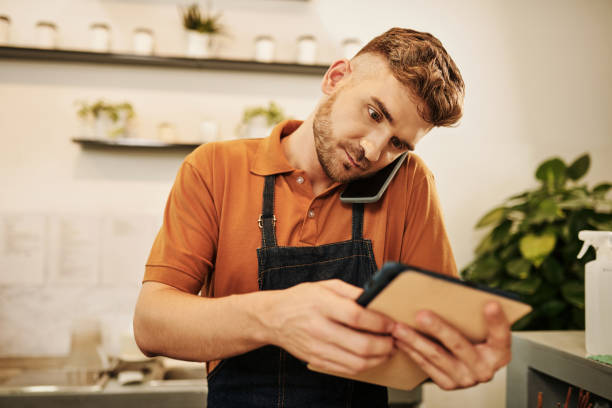 istock Cafe Waiter Talking on Phone 1405534613