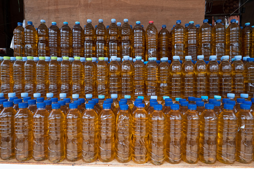 selectively focus on plastic bottles containing bulk cooking oil, in Indonesian it is called minyak goreng curah