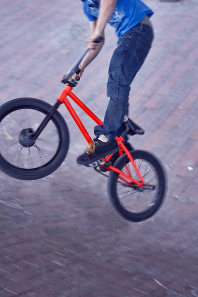 Low angle view of male mountain bike cyclist exercising whip negative trick against the sky. Copy space.
