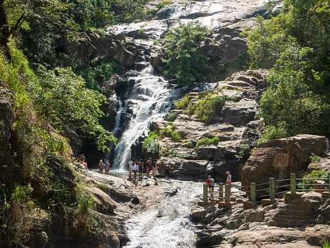 Ella, Sri Lanka - March 9, 2022: Beautiful view of the Ravana Ella waterfall, 25 meters high. People came to the waterfall and admire nature.