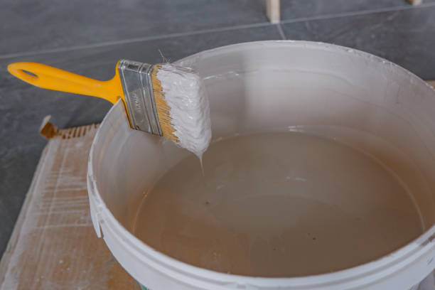 istock the paint brush is fixed in a bucket above the paint.construction works, 1405543746