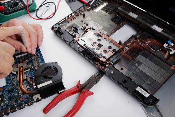 istock a computer repairman disassembles, repairs and does preventive maintenance for a broken laptop. 1405543985