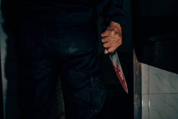 istock Behind the murderer, he held a blood-stained knife that killed his victim in a very terrifying and terrifying way. 1405544941