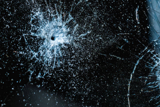 istock Bullet hole in a glass on the black background.closeup. 1405545211