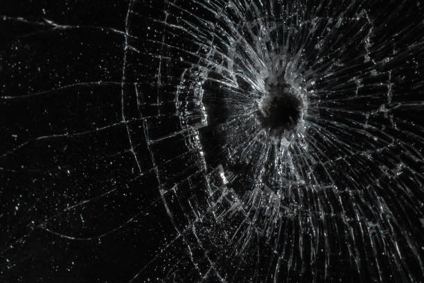 istock Bullet hole in a glass on the black background.closeup. 1405545217