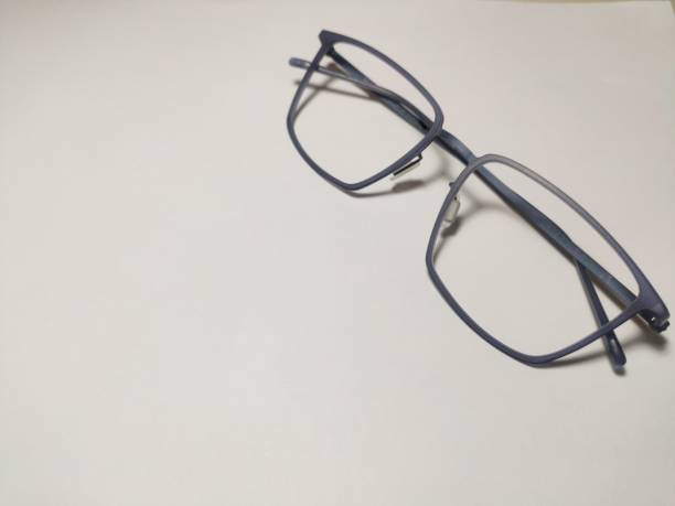 istock Reading glasses with black square frames on white paper that are great for a background 1405546365
