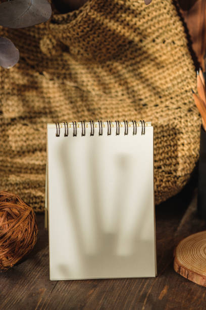istock blank sprial notebook with wicker bag and travel stuff on table with sunlight 1405546718