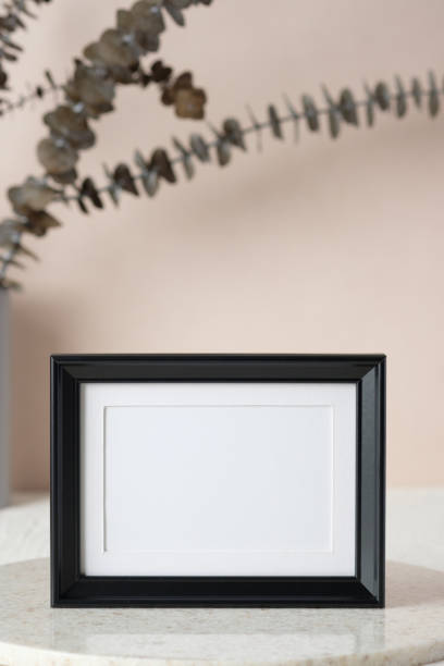 istock blank black photo frame mockup with eucalyptus brancch at peach wall 1405547930