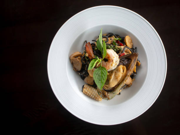 istock Black spaghetti with seafood on black table. 1405548222