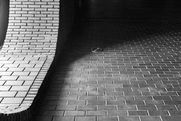 The sun shines on the ground paved with bricks, the brick wall