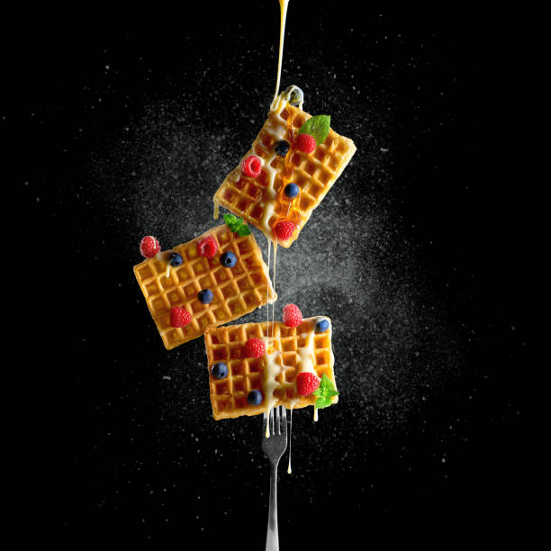 istock Waffle levitation. Waffles with raspberry and blueberries are watered with honey. Food levitation. 1405556977
