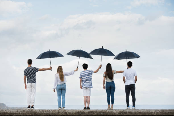 istock Teamwork and sacrifice concept with umbrellas 1405559972