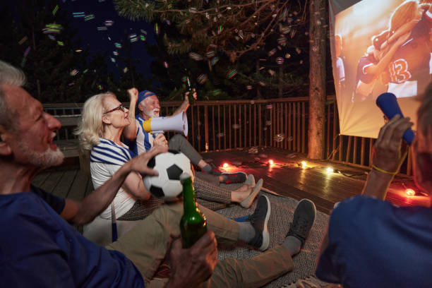 istock Watching a successful soccer match through projection screen on a terrace at night! 1405560138