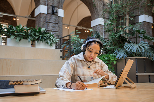 Beautiful teenage female student studying in a public library