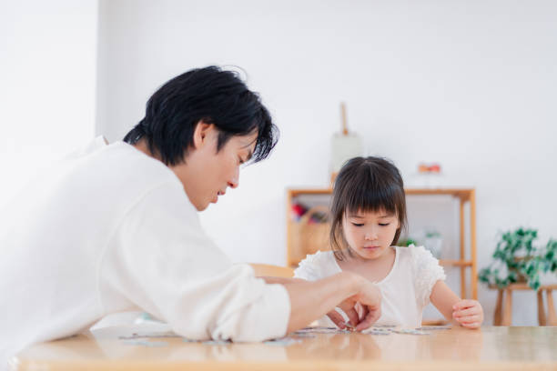 istock A little girl playing a puzzle game with her daddy 1405561617