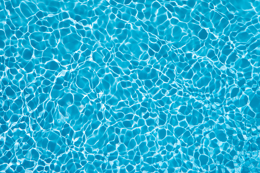 Beautiful blue water in swiming pool with sun reflection