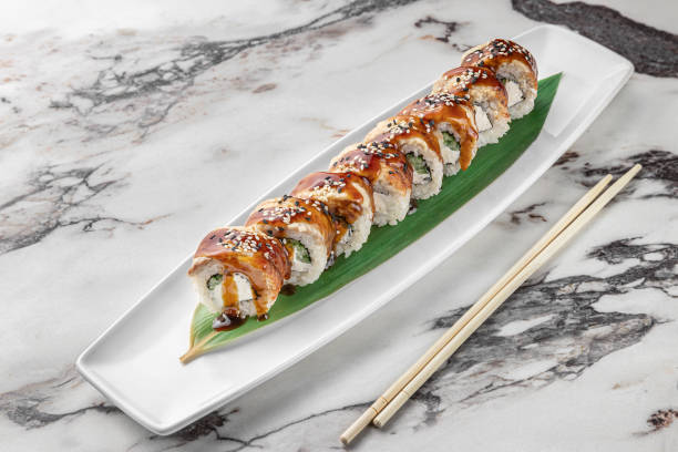 istock set of philadelphia rolls with eel and green bamboo leaf in a white ceramic plate with chopstick on a bright textured marble background, side view 1405562985