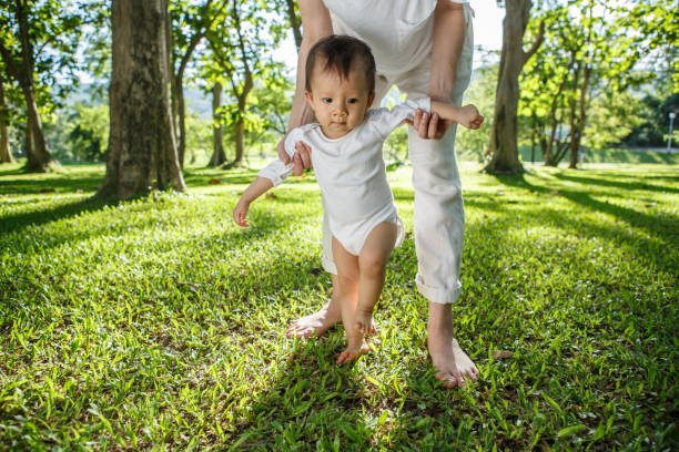 istock Legs of mother and baby. First steps. 1405564146