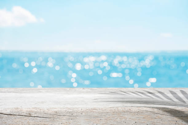 istock Blurred sunny ocean background with wooden table for product display 1405564335