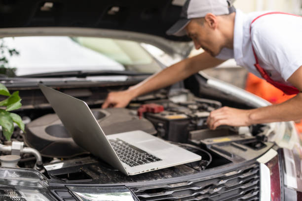 istock Mechanic with laptop near car engine. Modern car diagnostic program on screen. Car service concept 1405564554